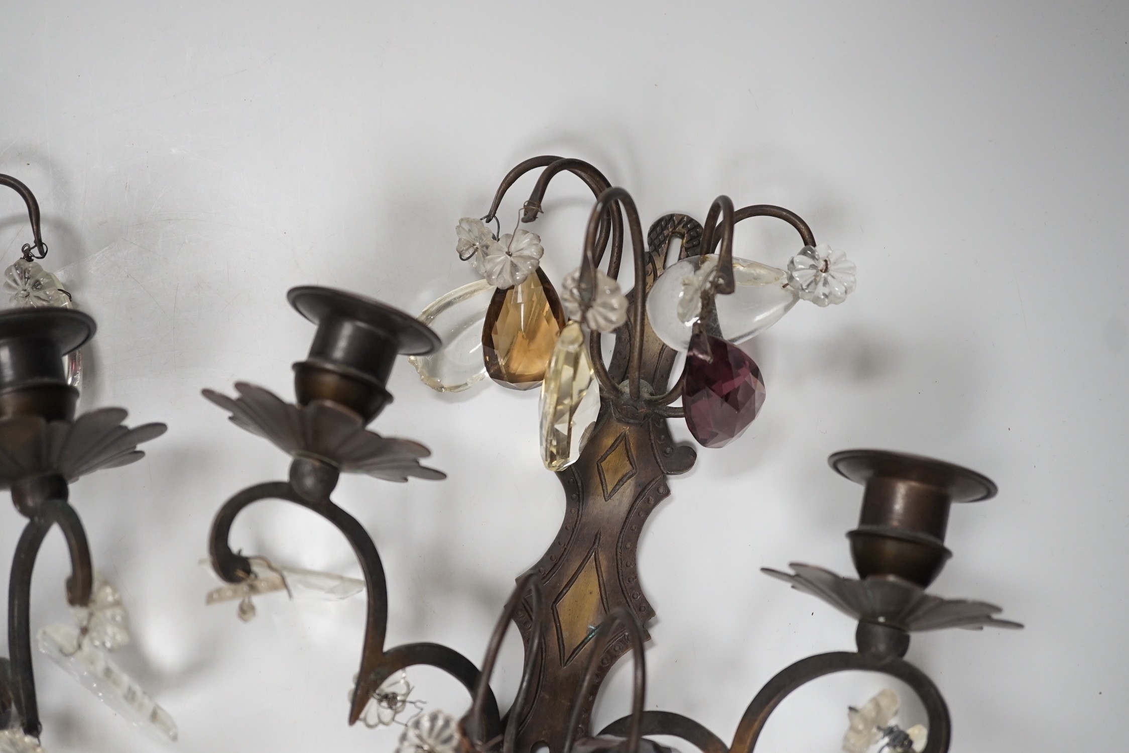 A pair of bronze or brass two branch wall sconces with cut glass drops